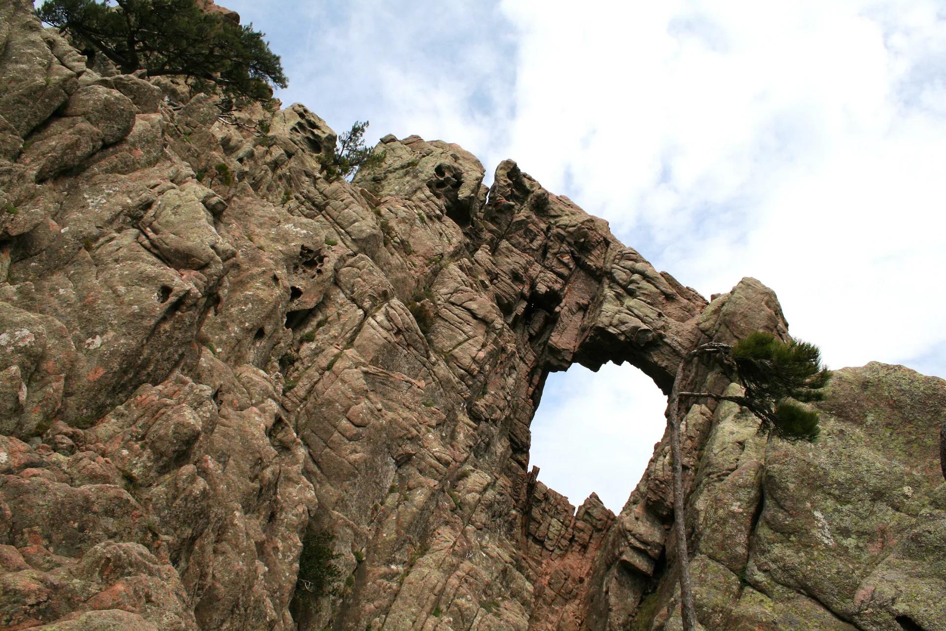 L'arche rocheuse percée du Trou de la Bombe dans une paroi de granit du massif de Bavella, vue d'en bas