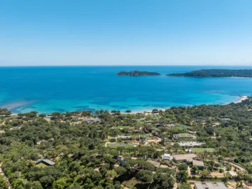 Vue aérienne du golfe de Pinarello : maquis et maisons au premier plan, îlot de la Ruscana, île de Pinarellu et sa tour au large