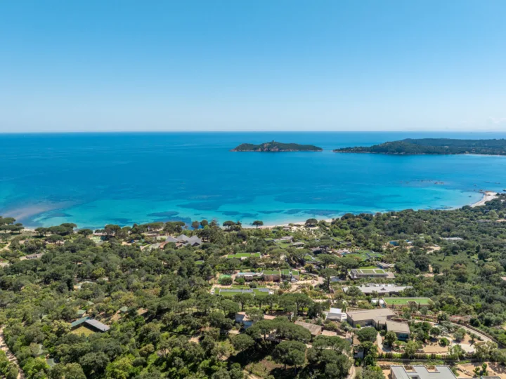 Vue aérienne du golfe de Pinarello : maquis et maisons au premier plan, îlot de la Ruscana, île de Pinarellu et sa tour au large