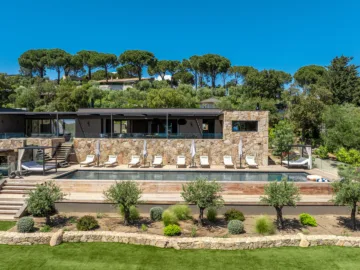 Façade en pierre, terrasse et piscine de l'Hôtel Villa Padulaccia sous les pins