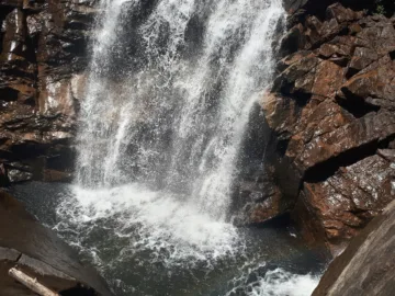 Chute d'eau de Piscia di Gallu tombant entre des parois de granit sombre dans un bassin