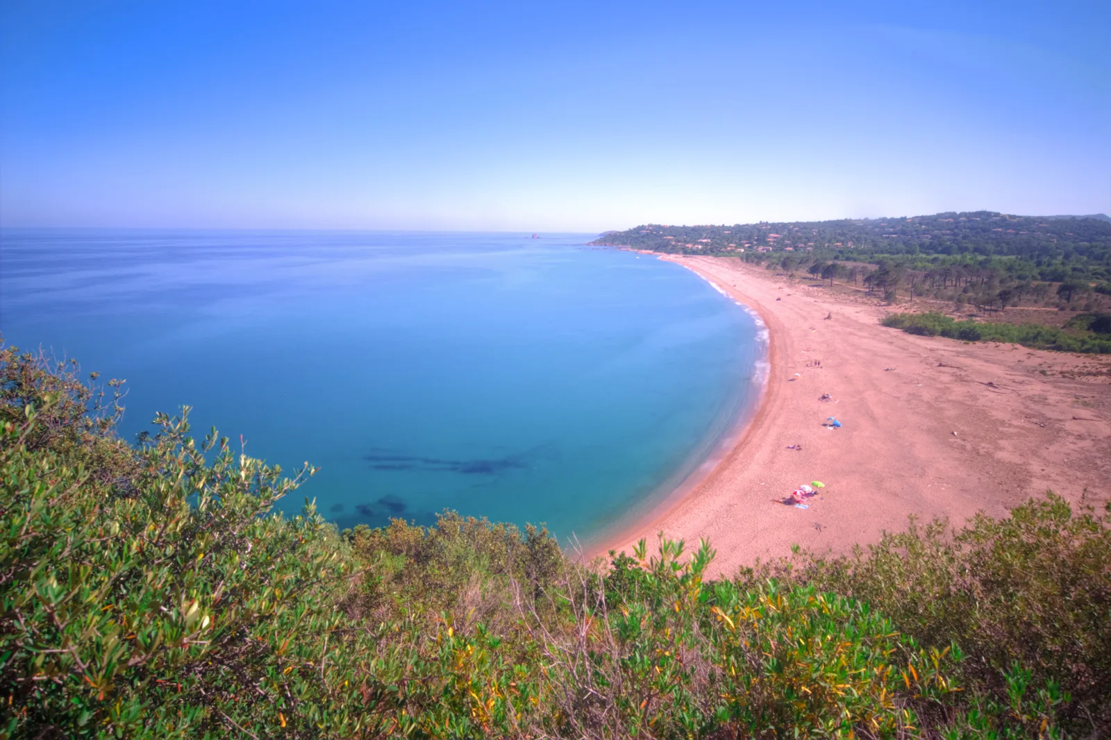 Longue plage courbe de sable du Lavu Santu bordée de maquis, vue depuis le sentier du littoral