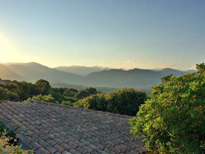 Toit de tuiles, collines de maquis et montagnes en lumière rasante, vus depuis Sainte-Lucie-de-Porto-Vecchio